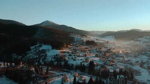 Scenic Aerial View of a Village in the Mountains at Sunrise in Winter