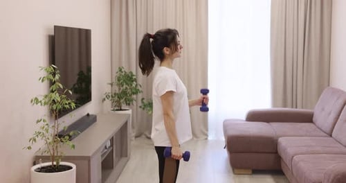 Woman Lifting Weights Indoors at Home