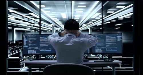 Young Adult Working on Dual Monitors in Modern Office