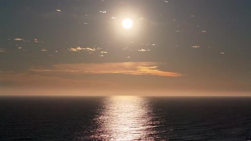 Scenic drone footage capturing the serene beauty of a sunset over the shoreline and ocean.