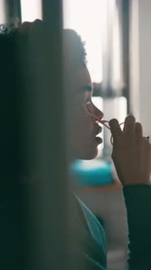 Woman Using Eyelash Curler in Bright Bathroom