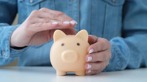 Person Stroking and Protecting Piggy Bank Money Accumulation and Insurance