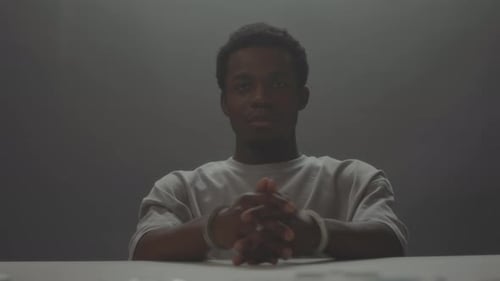 Young Man with Handcuffs at a Table