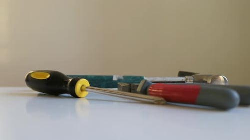 Mann schnappt sich Schraubenzieher, Zangen und Hammerwerkzeuge, Nahaufnahme