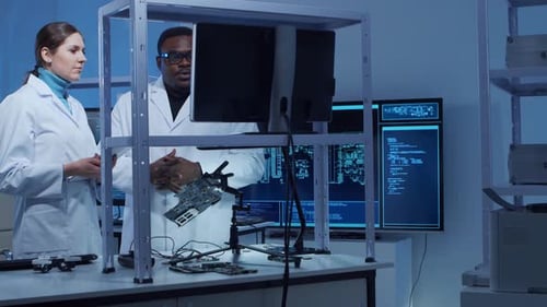 Scientists Discussing Circuit Board in Research Lab