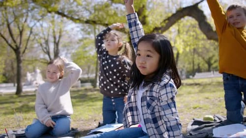 Happy multi ethnic children enjoying homeschool education in the city park