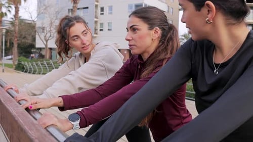 Women Stretching Together in Urban Park