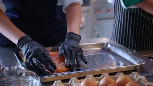 Chef Seasoning Salmon Fillet with Black Gloves