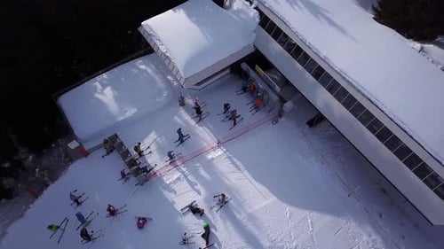Luftaufnahme des Sessellifts von oben. Wenige Leute für den Transport im Skigebiet. Skifahrer und Snowboard