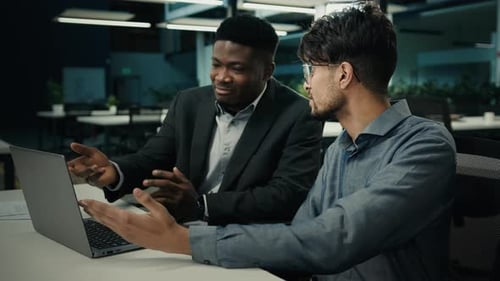 Businessmen Collaborating on a Laptop in an Office