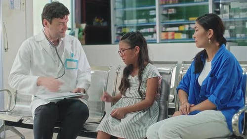 Medical Worker Greeting Teenage Girl at Hospital during Appointment