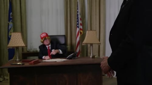 Adult Dressed in Suit Gesturing at Desk