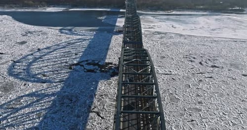 Bridge with traffic over a frozen river with ice floes.