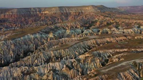 Cappadocia landscape with tuff stone formations after sunrise, backwards aerial