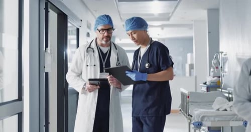 Tablet, hospital and doctors in discussion for teamwork, collaboration and advice for diagnosis