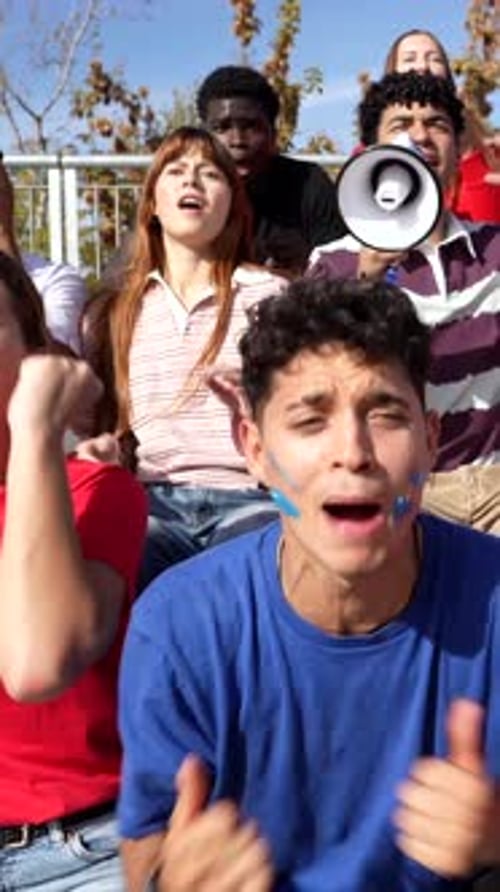 Group of Excited Fans Celebrating and Cheering a Victory in a Stadium