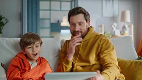 Man and Boy Using Tablet in Living Room