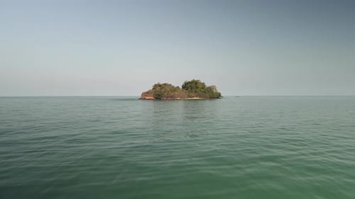 aerial drone approaching small deserted tropical island .