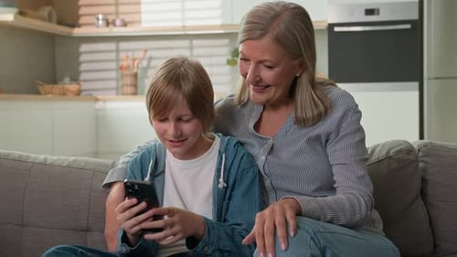 Grandmother and Grandson Using Smartphone at Home