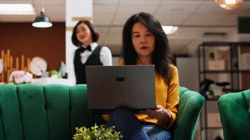 Woman Uses Tablet in Modern Hotel Lobby