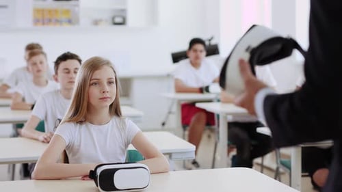 Students Sitting at Desks Listening to Teacher in Classroom