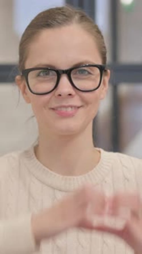 Smiling Woman Makes Heart Shape with Her Hands