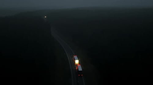 Trucks Traveling on Rural Road at Night