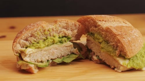 American Burger with Fish or Chiken Cutlet with Green Saladonion and Guacamole on Top Closeup Chef