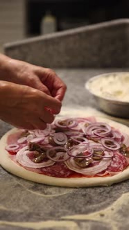 Der Koch bereitet köstliche Pizza in einer professionellen Küche zu.