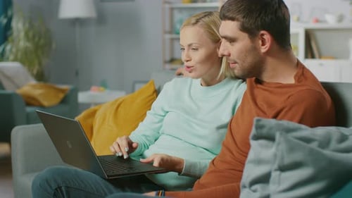 Affectionate Couple Using Laptop Together on Couch