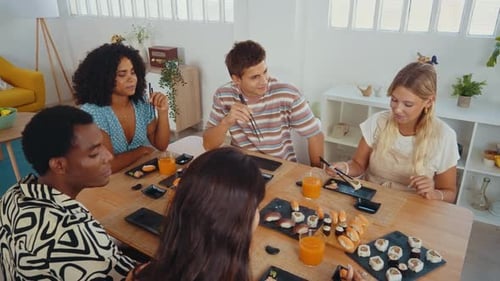 Group of friends eating sushi together at home.