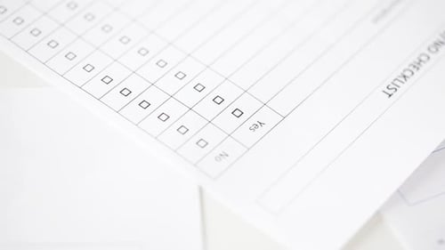 Filling out Yes or No checklist on white paper