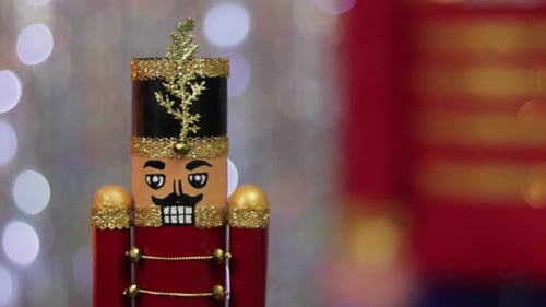 Christmas toy soldier nutcracker, same large figurine behind, bokeh.