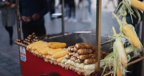Turkish street food seller with cart sells chestnuts and corn cobs
