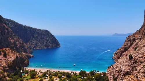 Serene coastal view of a hidden bay. Bright blue waters meet rugged cliffs in a tranquil bay