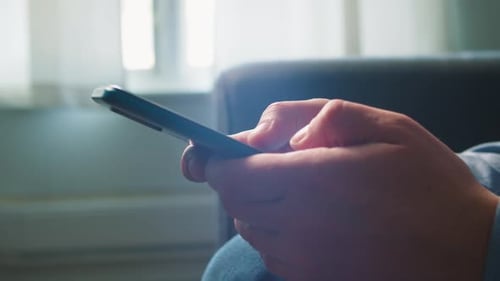 Hands Using Smartphone Inside Home During Daytime