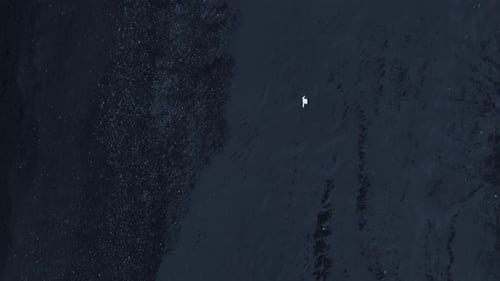 Drone Shot High Over Reynisfjara Beach Capturing Extremely Distant Man in White