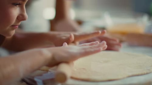 Children and Adult Rolling Dough in Kitchen
