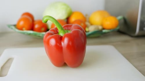 Vibrant Red Pepper on Cutting Board