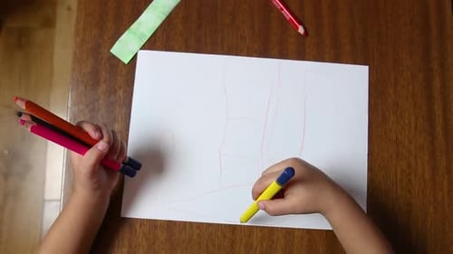 Kind zeichnet Kritzelei mit Buntstiften, Kleinkind lernt und spielt