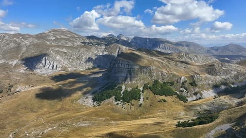 Flight over beautiful mountain peaks covered with grass. Mountain from above on a sunny autumn day.