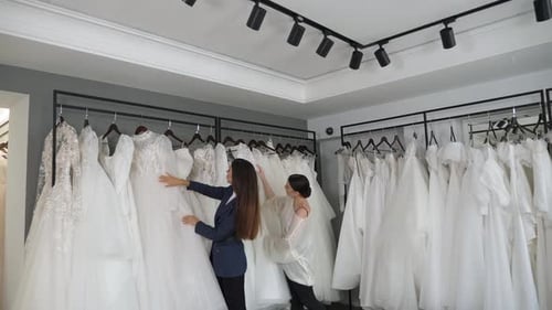 Duas lindas noivas escolhem um lindo vestido de noiva em um salão de casamento