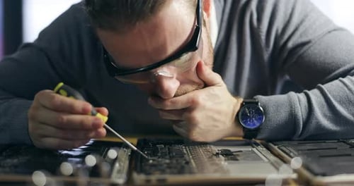 Electric maintenance, board and a man with tools for a computer service and focus on circuit
