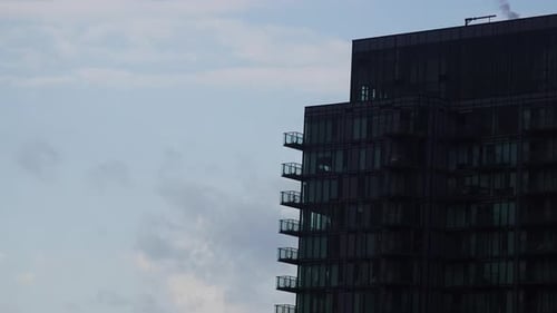 Time lapse video of clouds moving over office building in downtown district