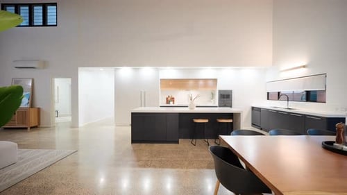 Open plan living dining kitchen with breakfast bar interior. Wooden seven seater dining table stone