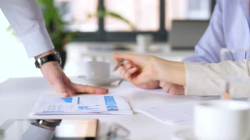 Businessman shows chart data to businesswomen during office meeting