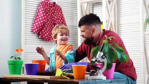 Father Ans Son Planting Sprout in a Plant Pot