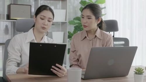Two Young Enthusiastic Businesswoman Working Together in the Office Workspace