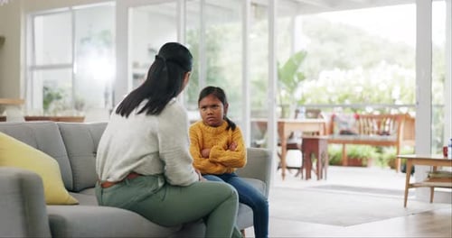 Upset Child Sitting on Couch with Adult