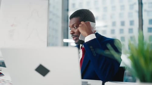 Boss in Office Portrait of Black Man Talking By Phone and Looking at Laptop Nervous African